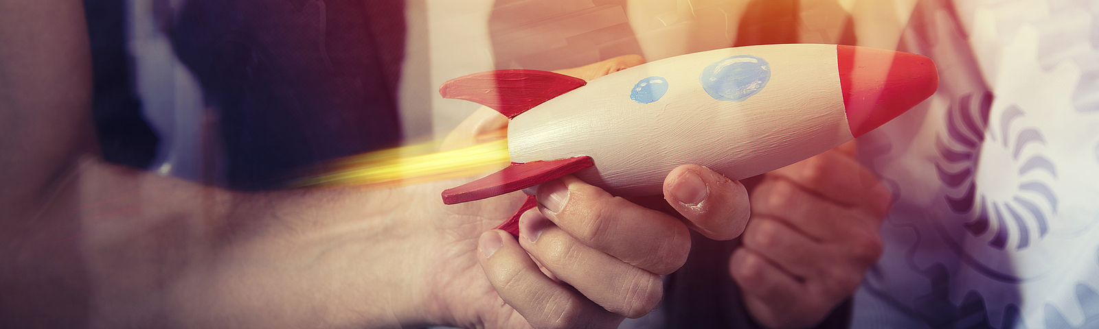 © Adobe Stock Photo: Hand hält eine Rakete aus Holz